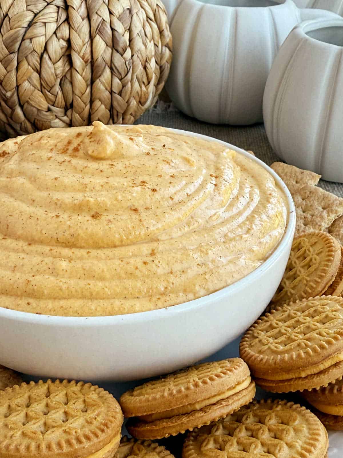 pumpkin cream cheese dip with cookies in serving bowl.