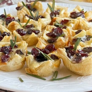 cranberry brie bites with rosemary on plate.