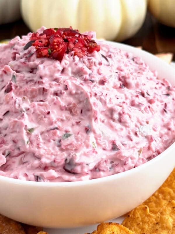 cranberry jalapeno dip in a serving bowl with chips.