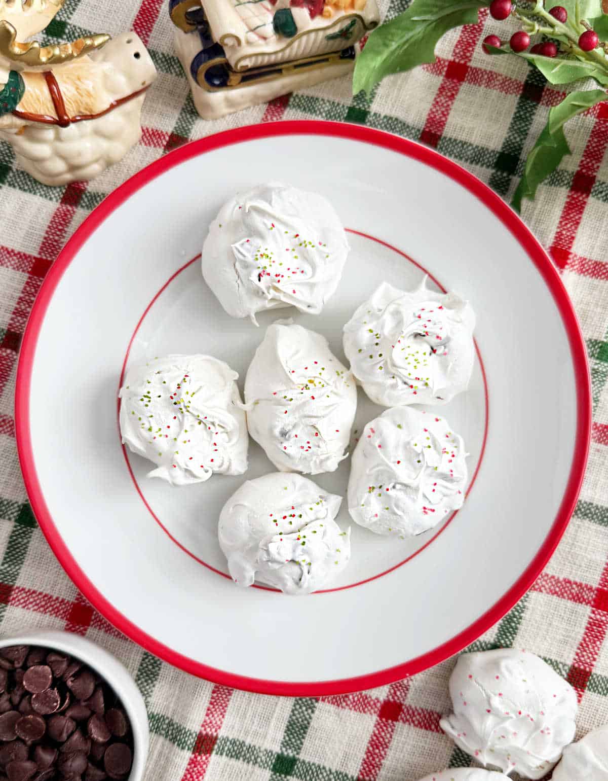 meringue chocolate chip cookies on a red and white plate.