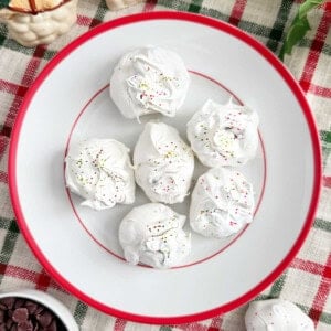 chocolate chip meringue cookies with red and green sprinkles on a plate.