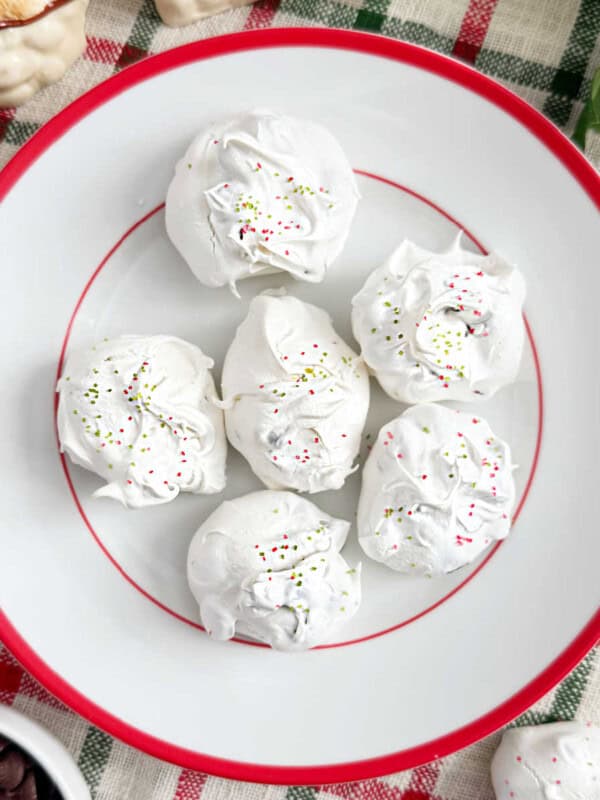 chocolate chip meringue cookies with red and green sprinkles on a plate.