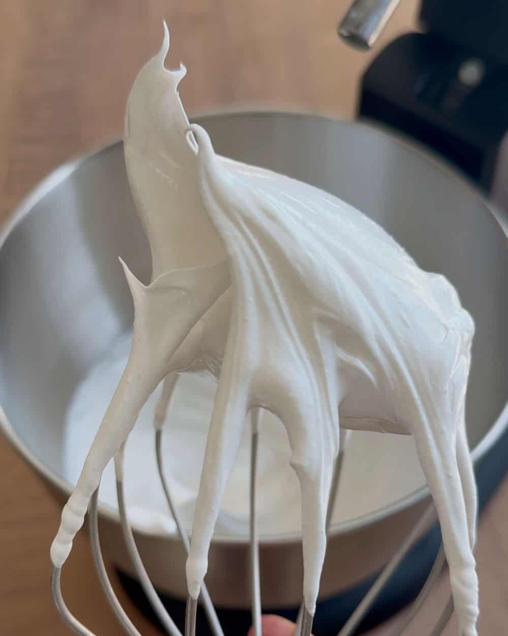 stiff egg whites on whisk.