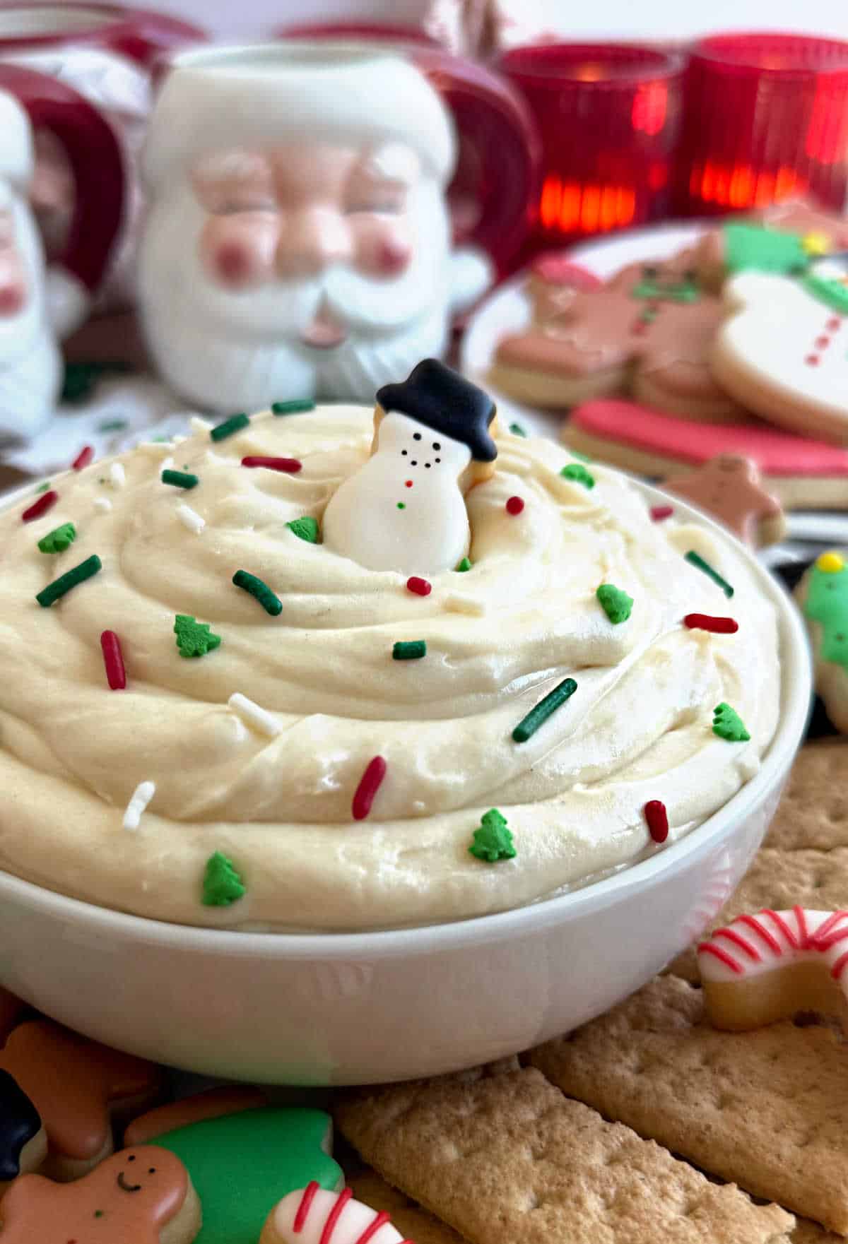 bowl of Christmas sugar cookie dip with sprinkles and dippers.