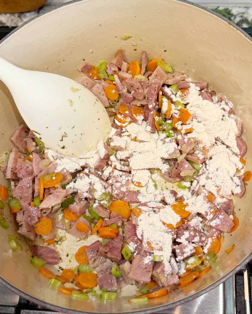 stir flour with veggies and ham.