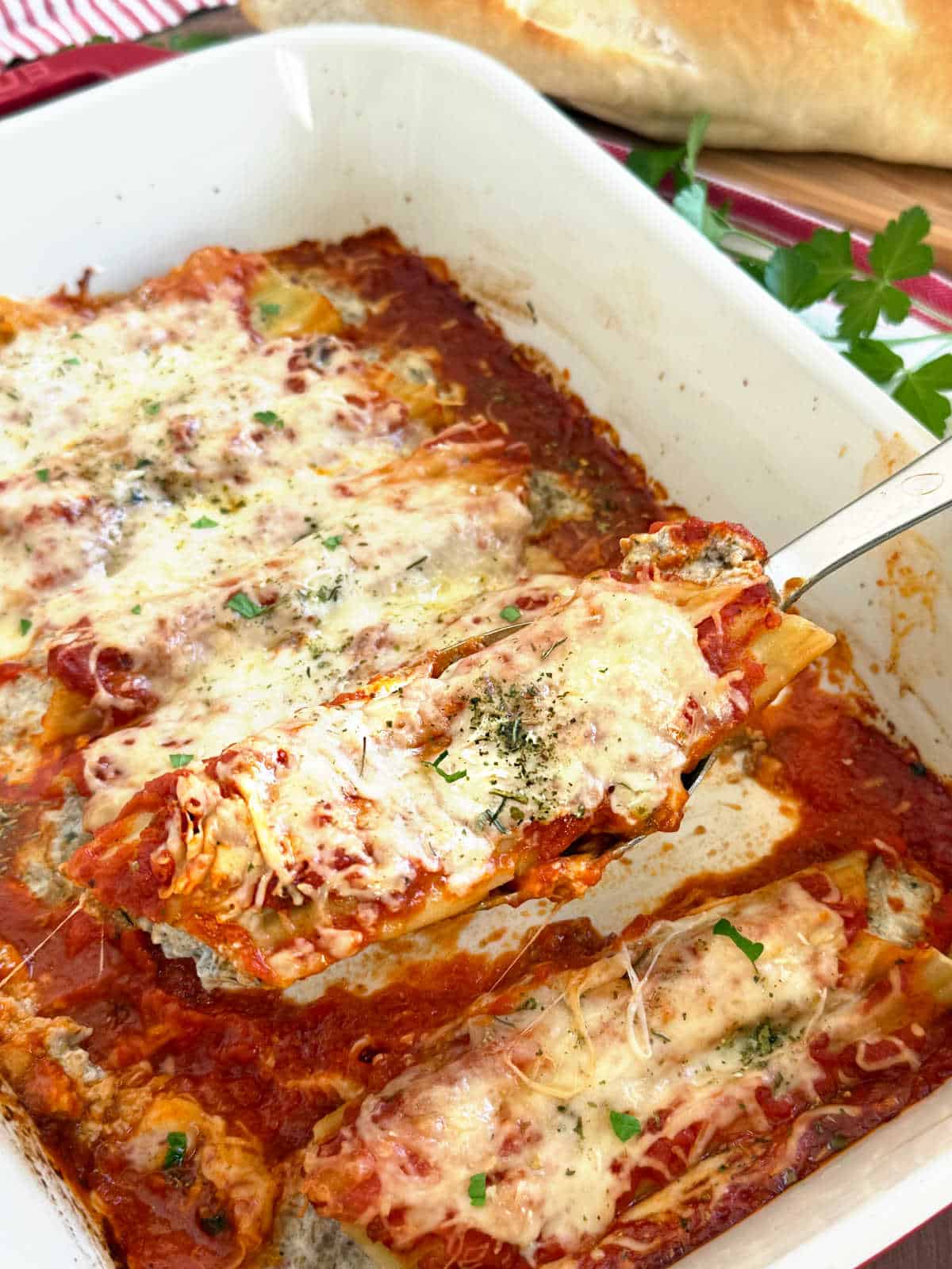 manicotti with meat on a serving spoon.