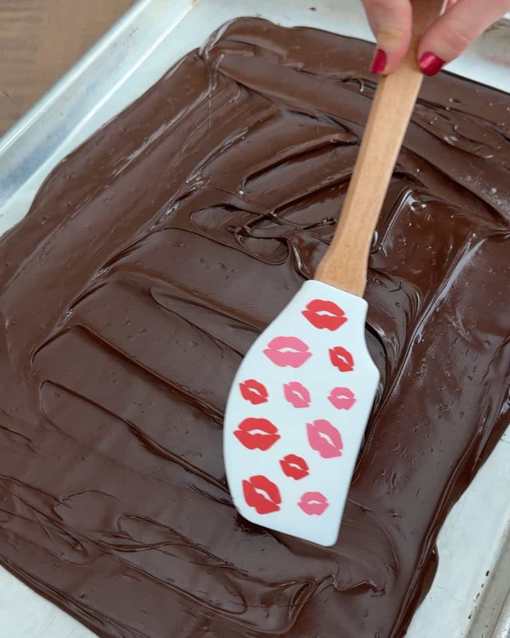 spread melted chocolate with kiss spatula.