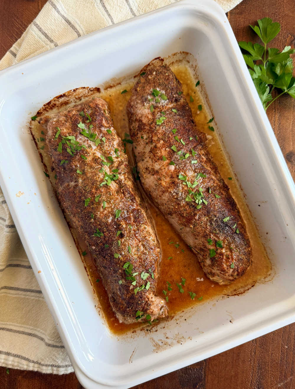 baked pork tenderloin with parsley in baking dish.