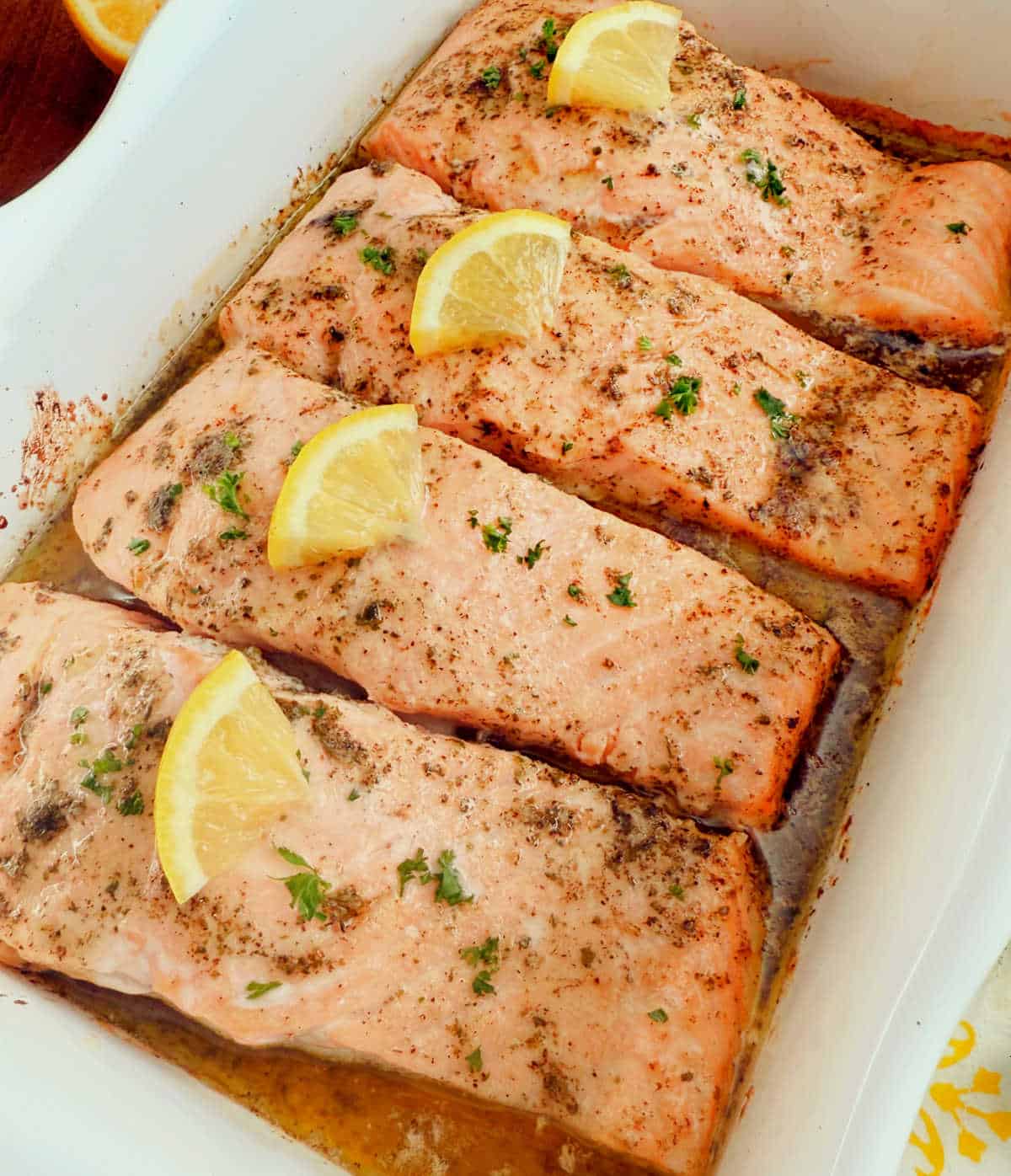 baked garlic butter salmon with lemon slices and parsley.