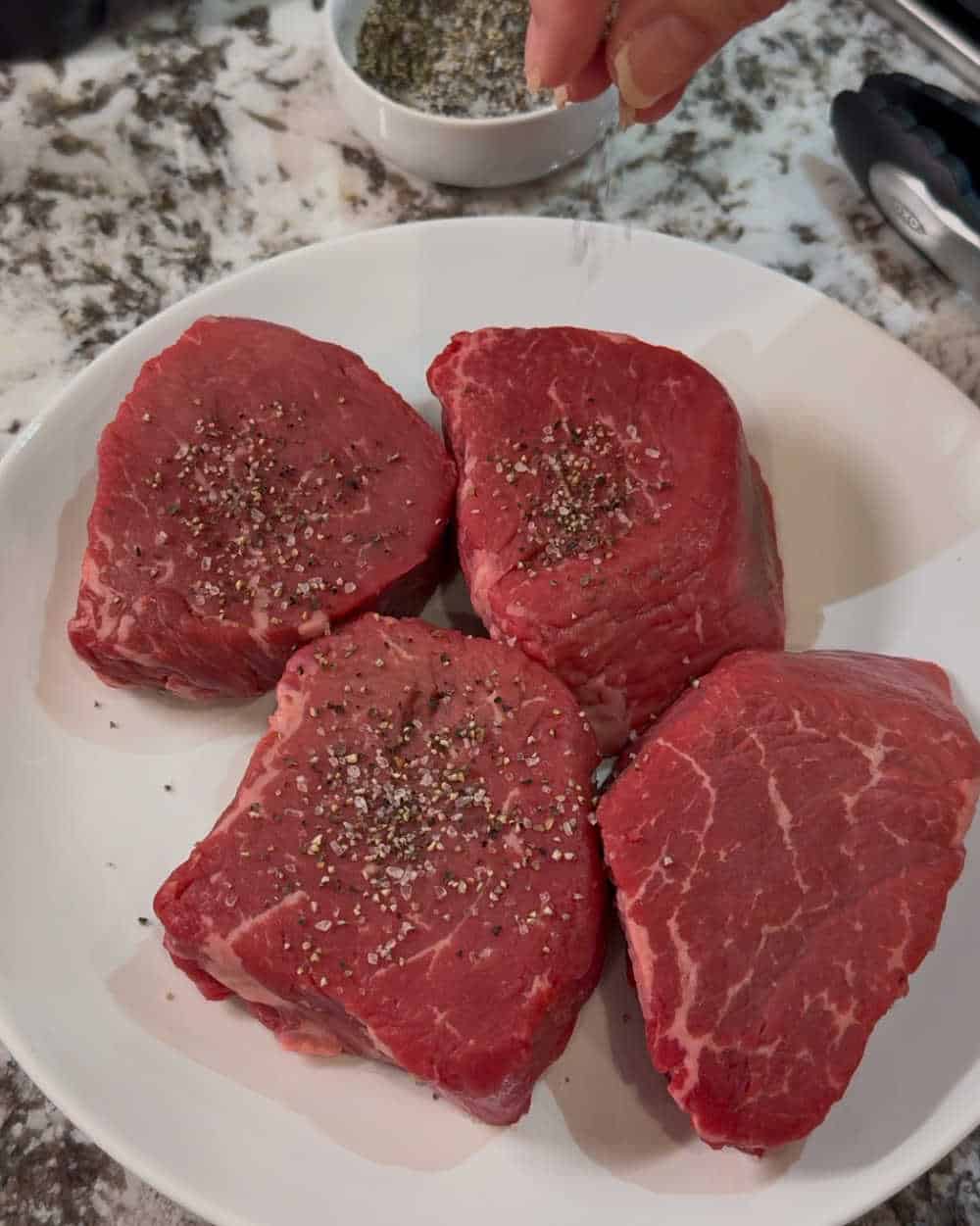 season beef filets with coarse pepper and salt.