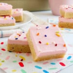 Sugar cookie bars with pink frosting and sprinkles.