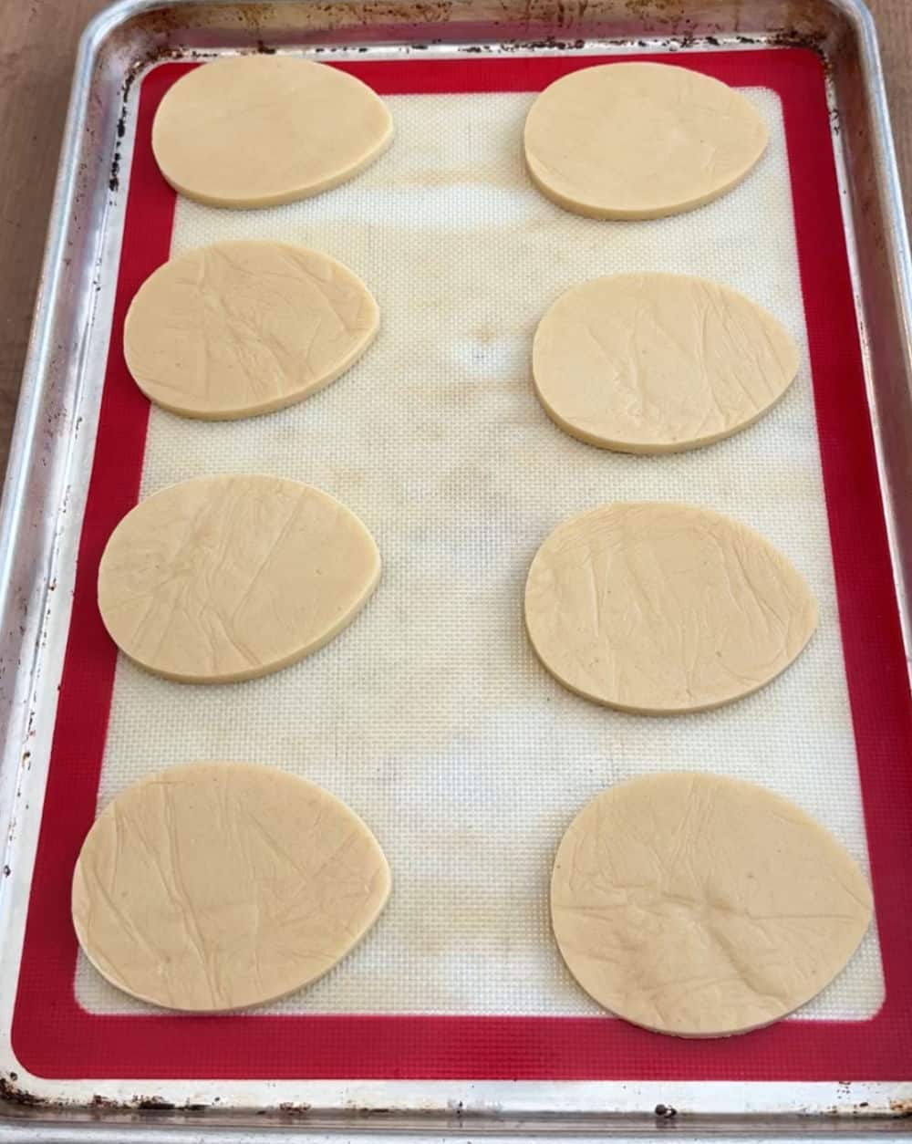 egg shaped sugar cookies on baking sheet.